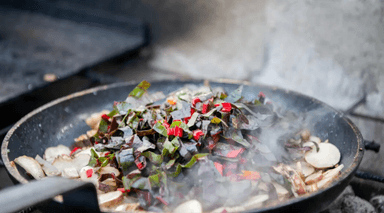 En stekpanna med rykande mat i.