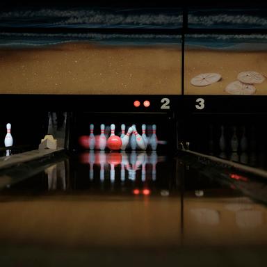 En bowling som slår ner flera känglor på en bowlingbana