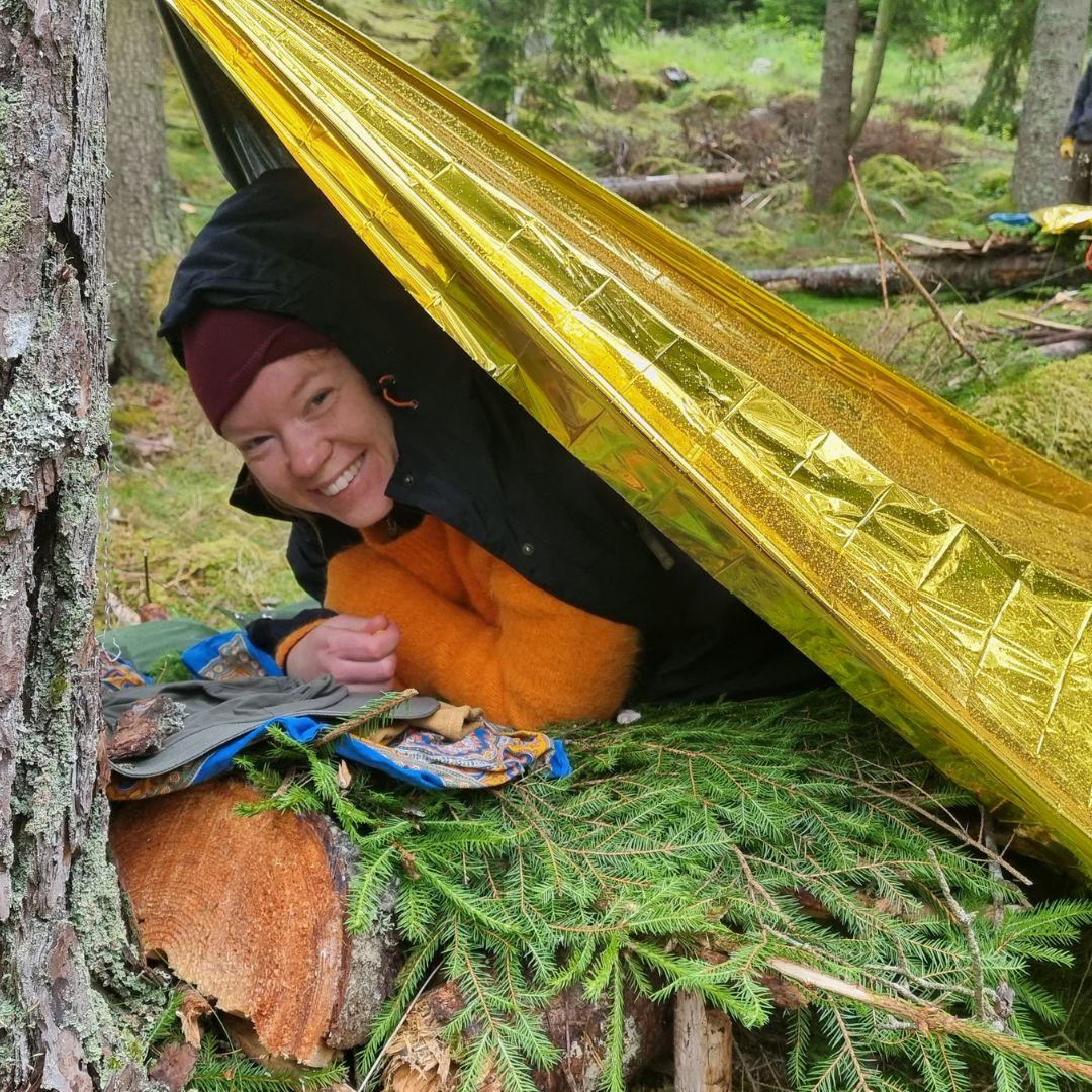 kvinna under ett vindskydd i skogen