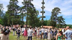 Människor runt en midsommarstång