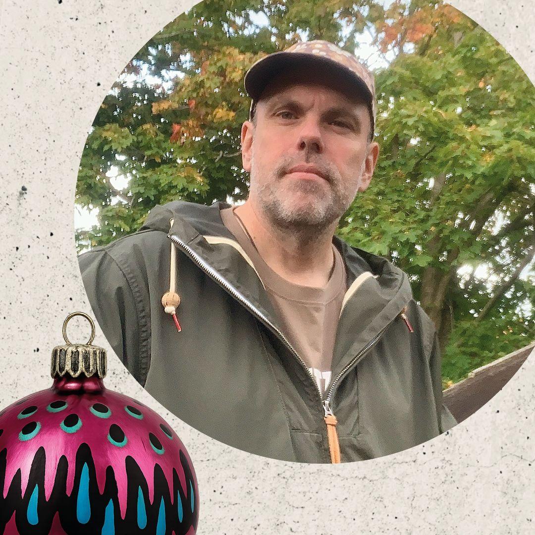 Bilden visar ett foto av föreläsaren Martin Lexelius Core. I nedre vänstra hörnet tittar en dekorerad julgranskula fram.