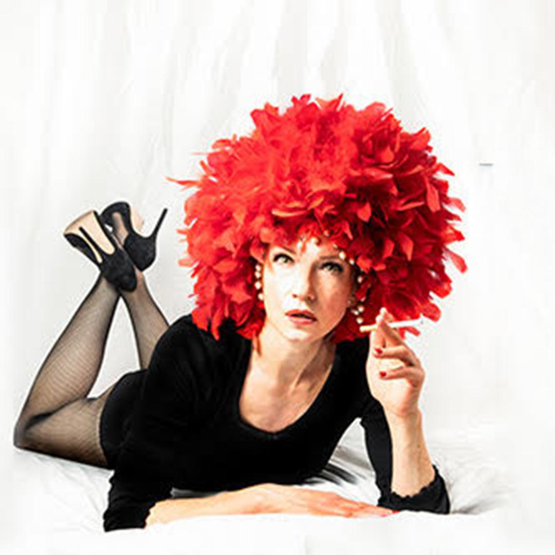 kvinna med svarta kläder och rött hår