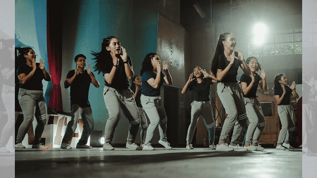 Ett glatt gäng människor dansar och klappar händer.