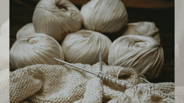 Vitt garn och en påbörjad stickning.