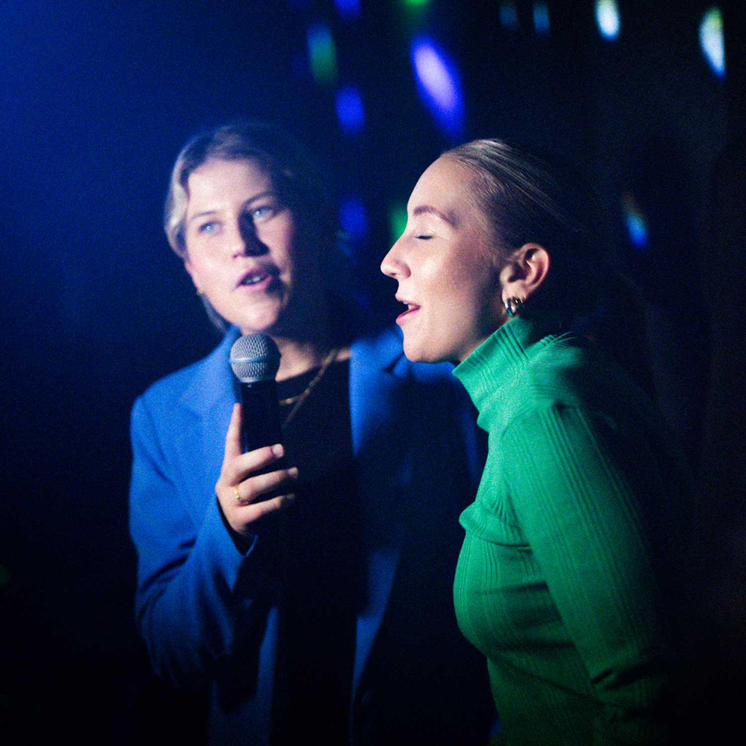 Två tjejer sjunger karaoke.