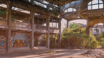 Ett övergivet hus, omgivet av grönska.