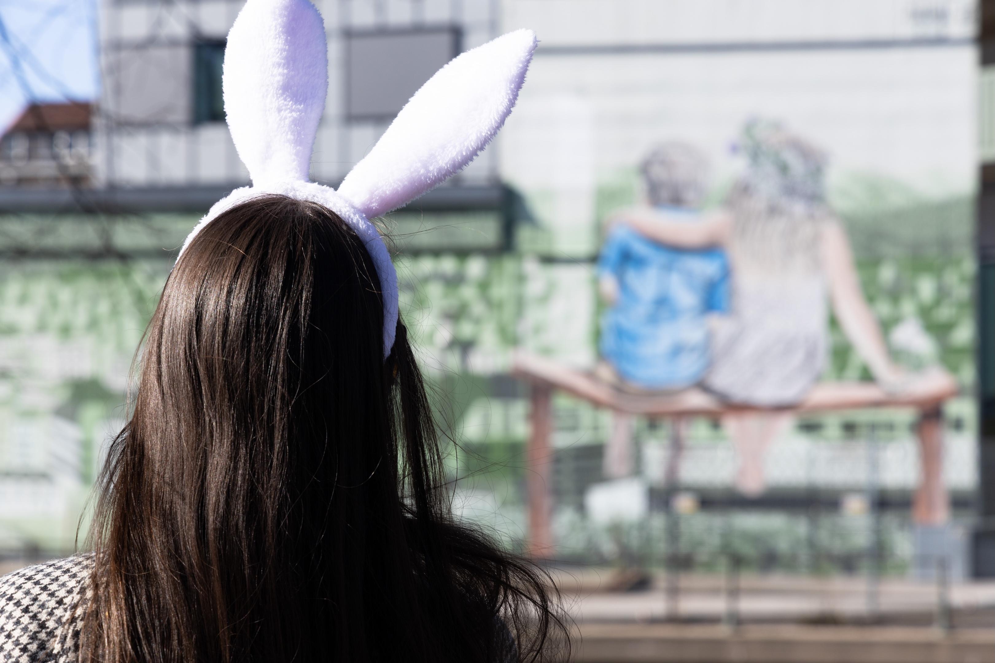 Tjej med kaninöron framför en muralmålning.