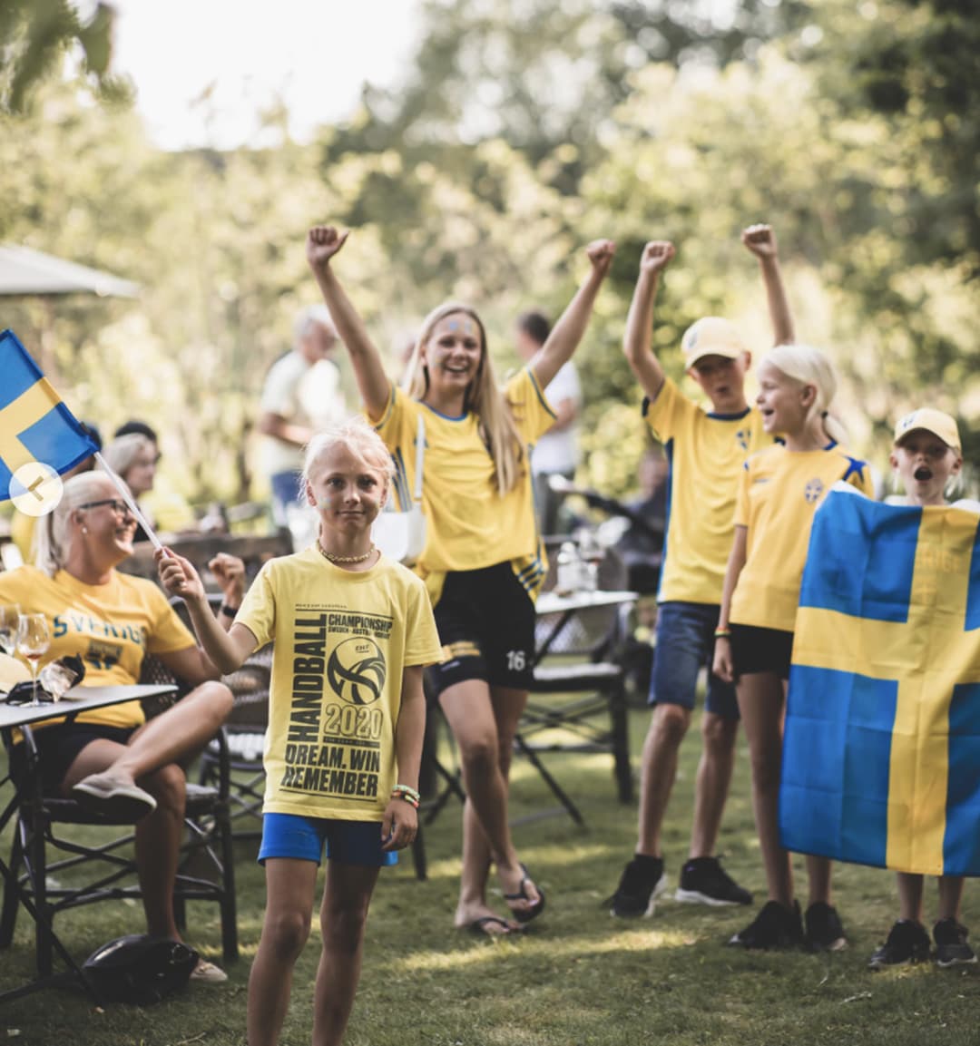 Sverigeklädda fotbollssupportrar i en trädgård