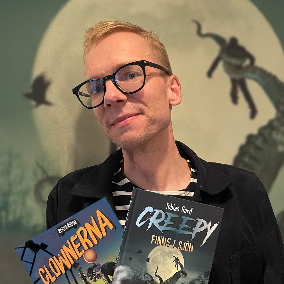 Tobias Gard håller böckerna Clownerna och Creepy