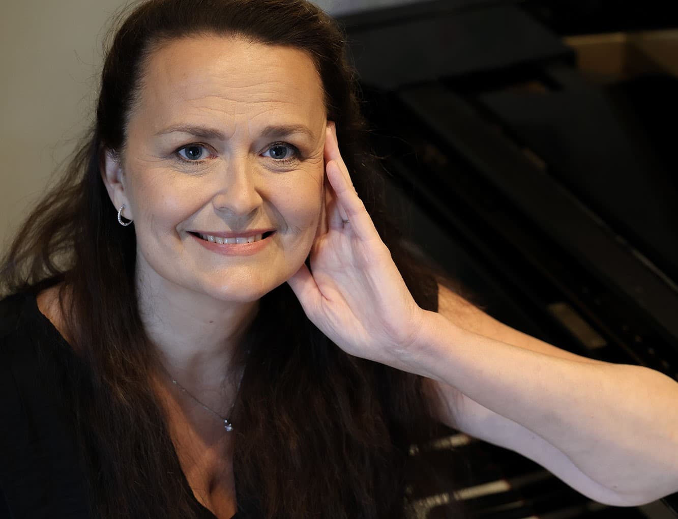 Helen Sällfors sitter vid en flygel