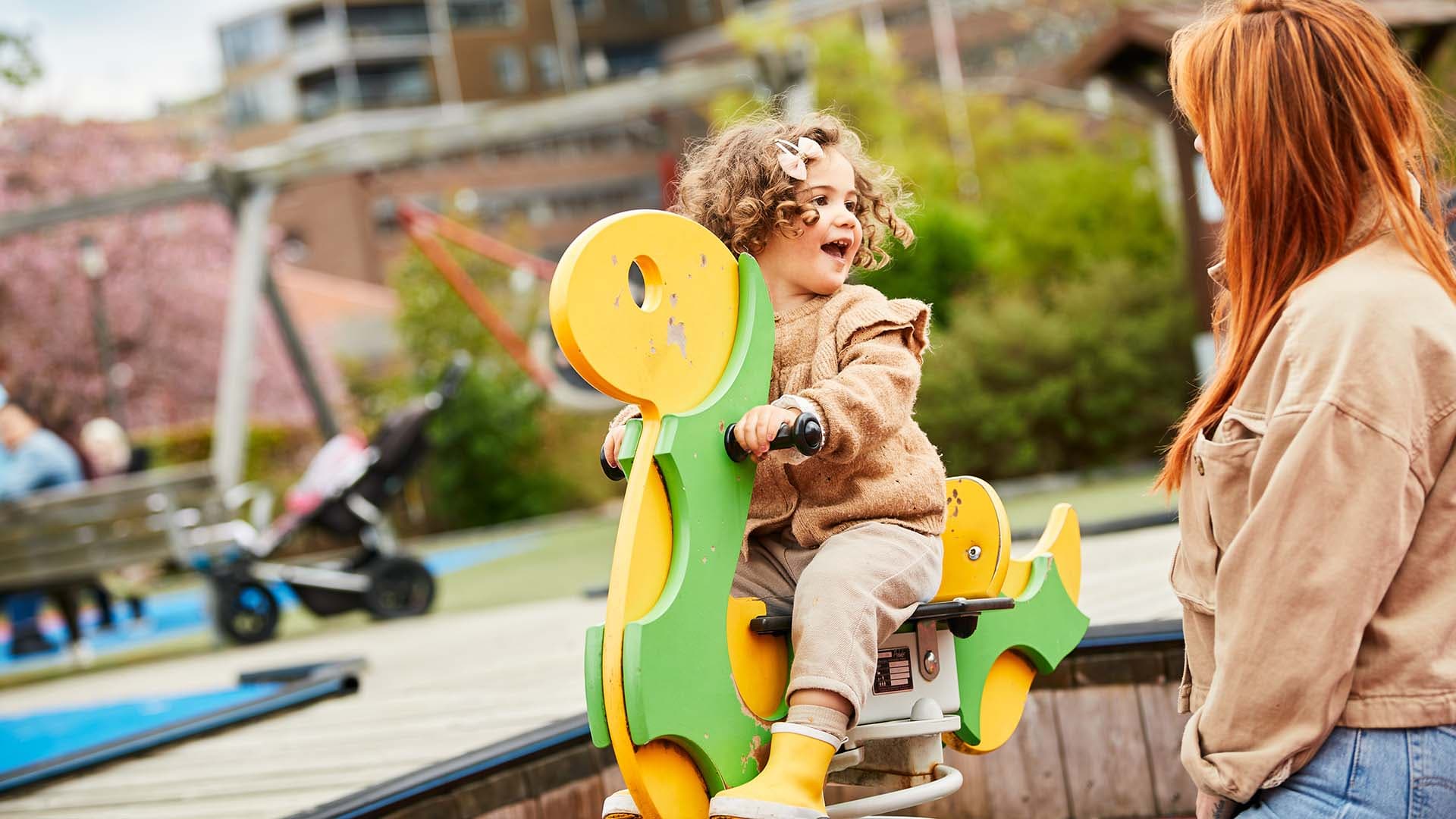 Liten tjej sitter på gunghäst