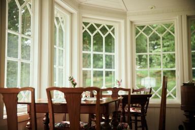 Stolar och bord i en inglasad veranda.