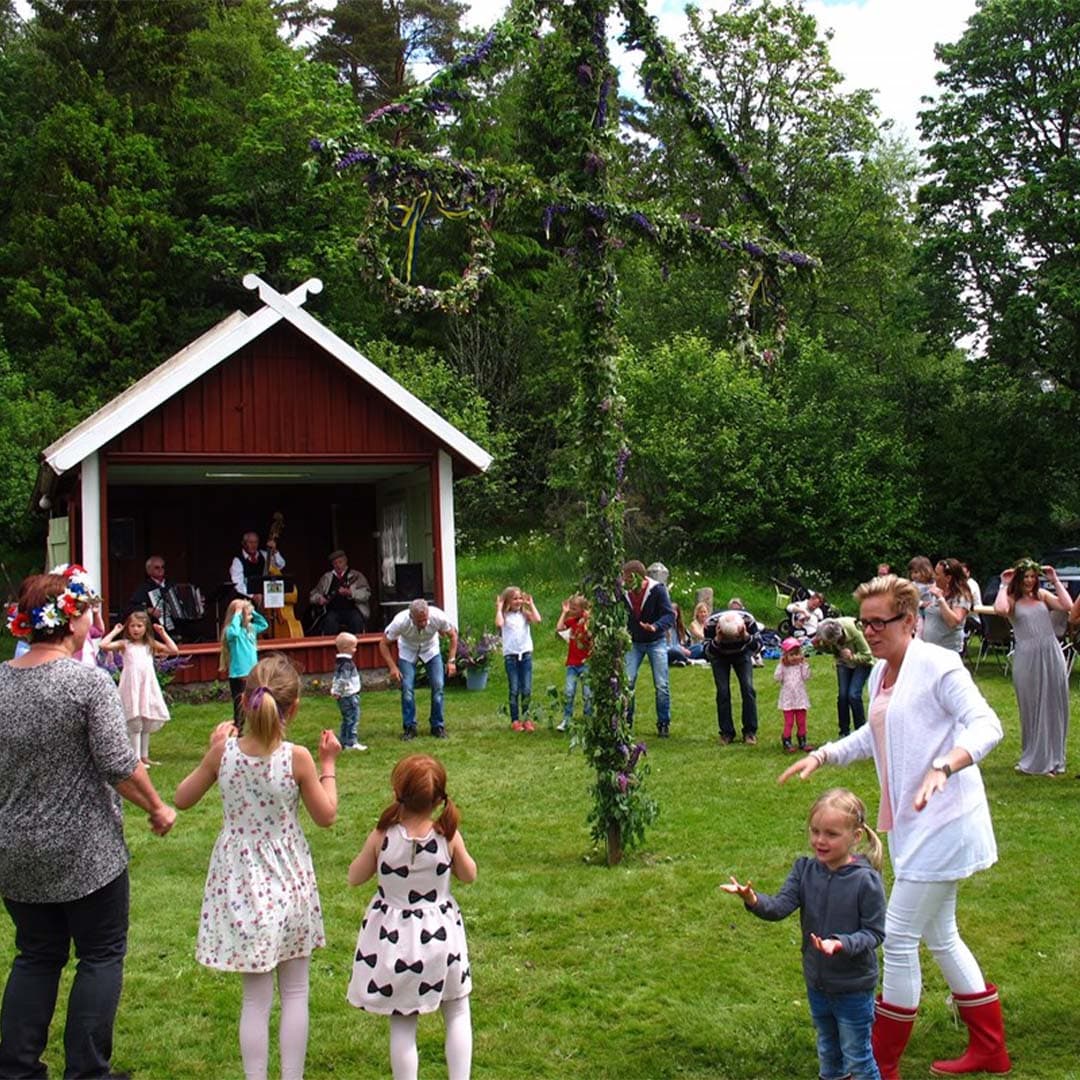 Folksamling runt en midsommarstång
