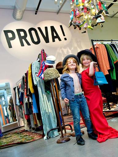 Två barn poserar utklädda i vuxenkläder