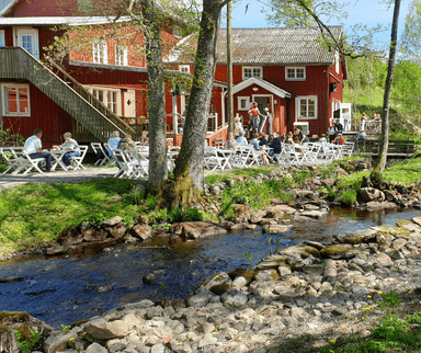 Rött hus bredvid en å.