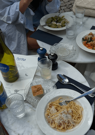 Pasta, dricka och menyer på bord.