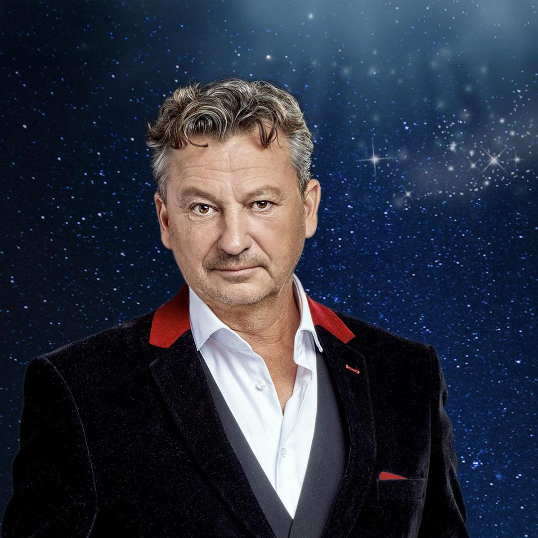 En man i kostym glittrande blå bakgrund