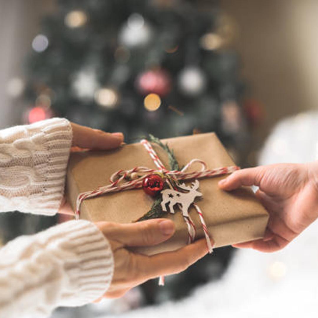 händer håller om et fint smyckat julpaket