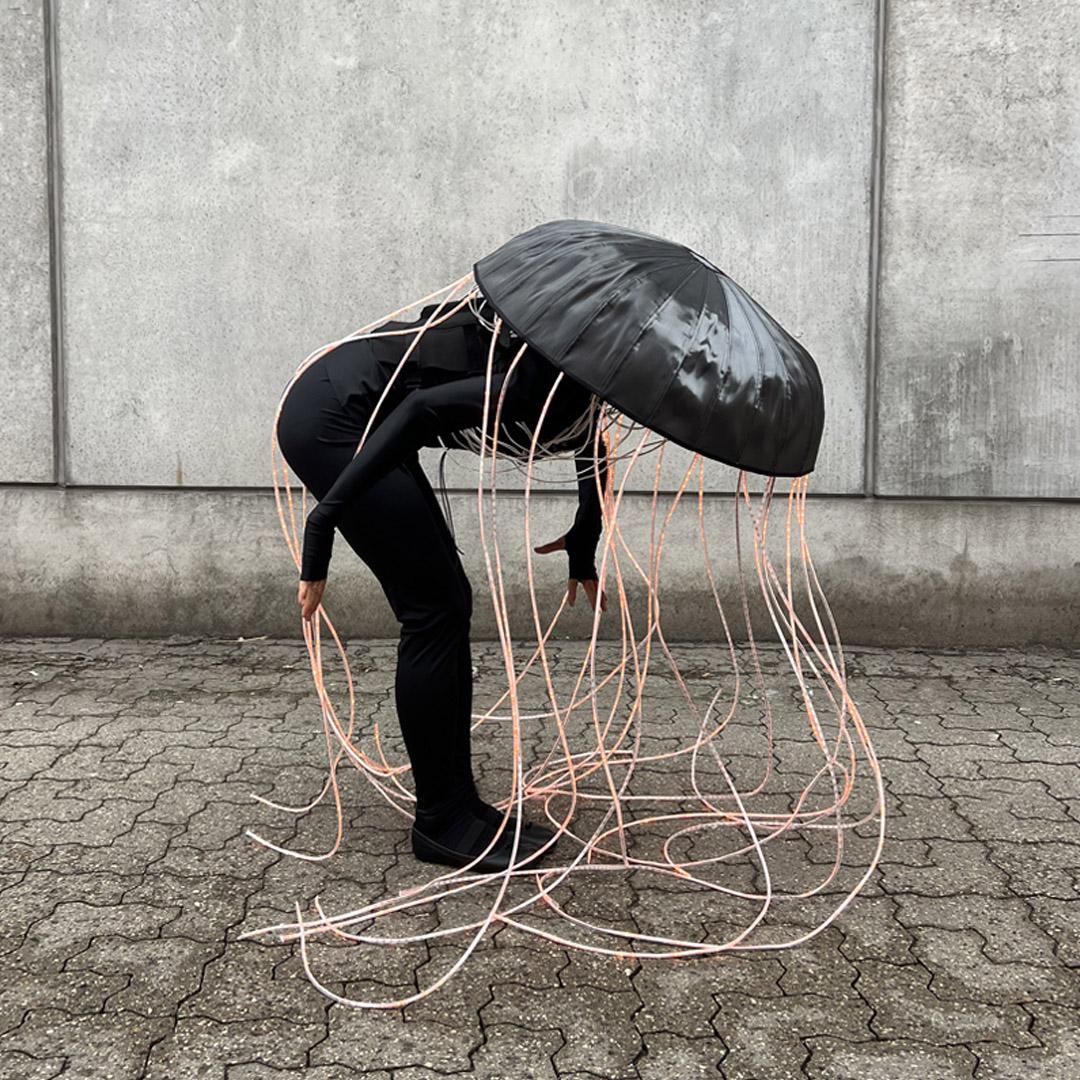 svartklädd person med svart paraply över huvudet konst