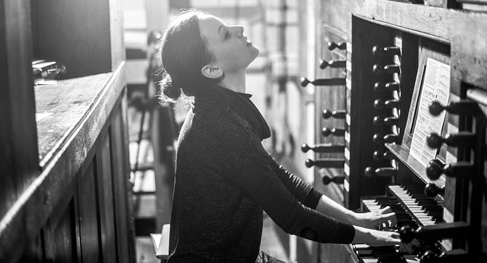 Ung kvinna spelar orgel.