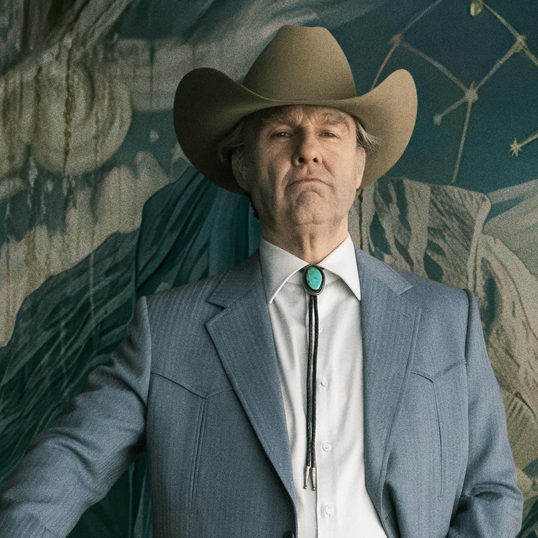 En man i grå kavaj och cowboyhatt