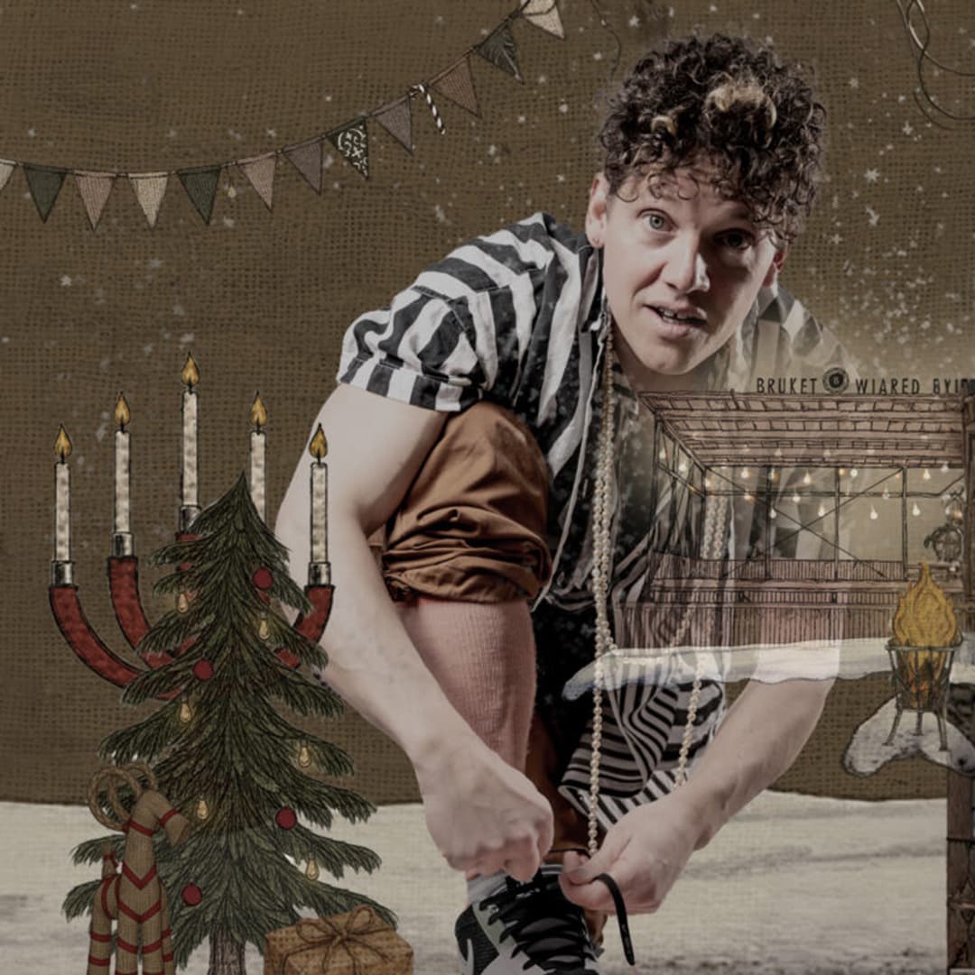 Man sitter ner och knyter sina kängor vie en liten julgran